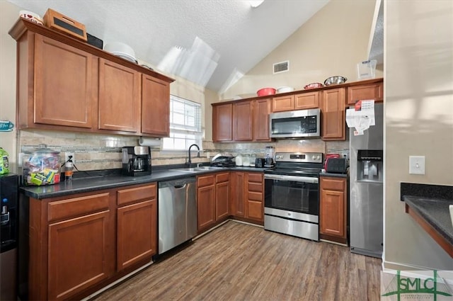 kitchen featuring decorative backsplash, dark hardwood / wood-style floors, sink, and stainless steel appliances