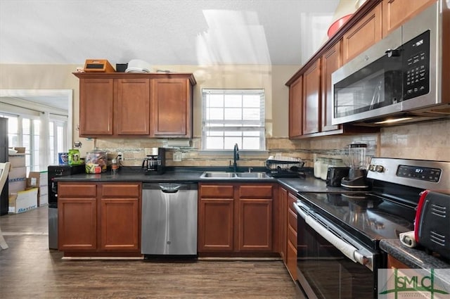 kitchen featuring tasteful backsplash, dark wood-type flooring, sink, and stainless steel appliances