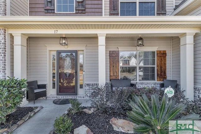 view of exterior entry featuring covered porch