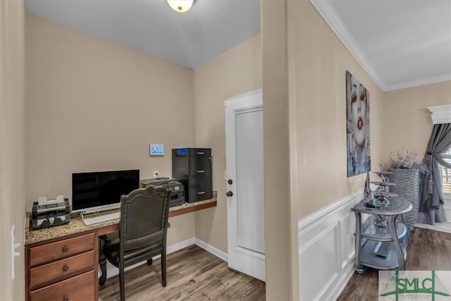 home office featuring light hardwood / wood-style floors, built in desk, and ornamental molding