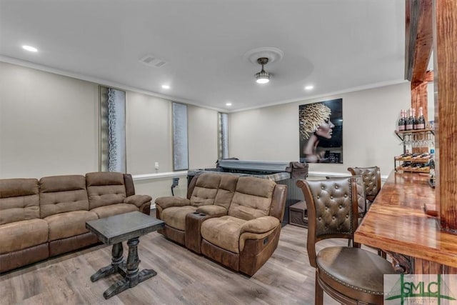 home theater room with light hardwood / wood-style floors and ornamental molding