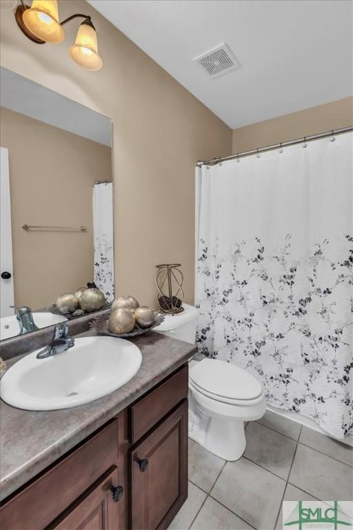 bathroom featuring toilet, vanity, and tile patterned floors