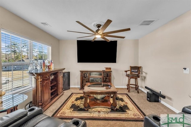 carpeted living room with ceiling fan