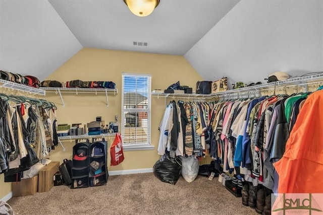 walk in closet with lofted ceiling and carpet floors