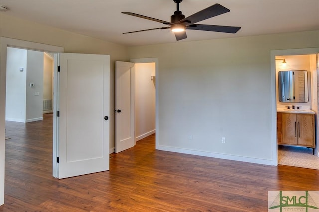 unfurnished bedroom with a sink, wood finished floors, visible vents, and baseboards