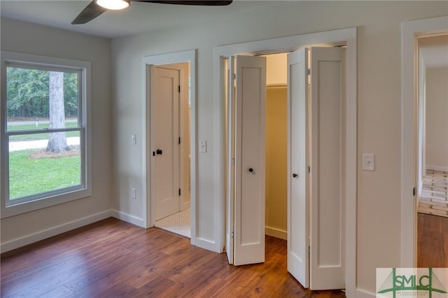 unfurnished bedroom featuring ceiling fan, baseboards, and wood finished floors