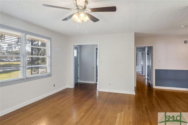 unfurnished room featuring ceiling fan, dark wood-type flooring, and a textured ceiling