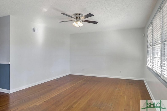 unfurnished room featuring hardwood / wood-style floors, ceiling fan, and a textured ceiling