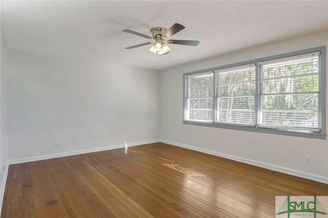 unfurnished room featuring wood-type flooring, a textured ceiling, a wealth of natural light, and ceiling fan