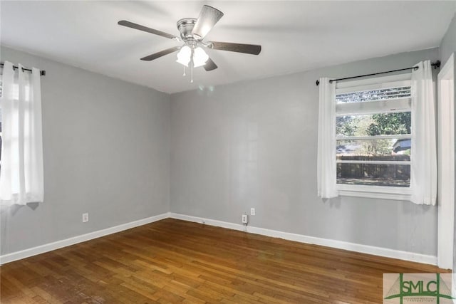 spare room featuring ceiling fan and dark wood-type flooring