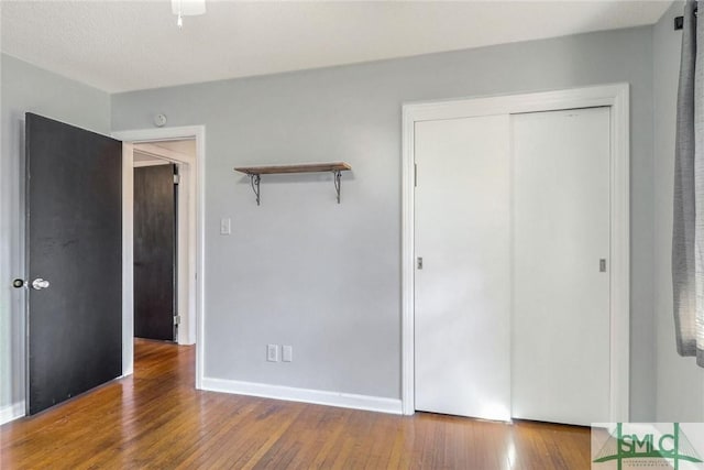 unfurnished bedroom with a closet and wood-type flooring