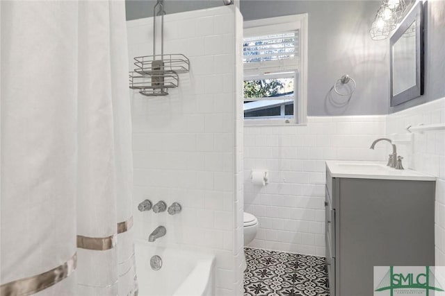 full bathroom with vanity, tile patterned floors, shower / bath combination with curtain, toilet, and tile walls