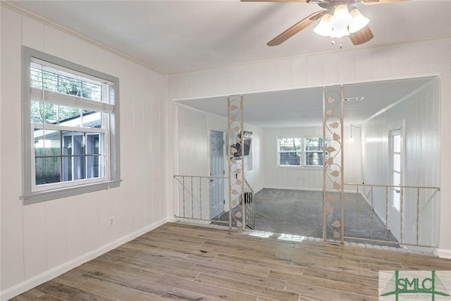 empty room with hardwood / wood-style floors, ceiling fan, and crown molding