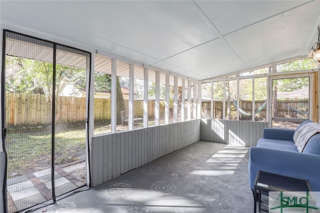 unfurnished sunroom featuring plenty of natural light and vaulted ceiling