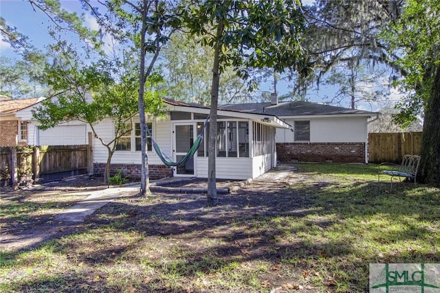 view of front of house featuring a sunroom, a front yard, and a garage