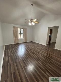 unfurnished living room with ceiling fan, dark wood-type flooring, and vaulted ceiling