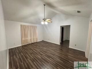 unfurnished living room featuring ceiling fan, dark hardwood / wood-style flooring, and vaulted ceiling