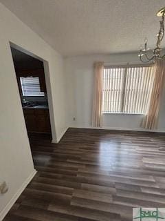 unfurnished room featuring dark hardwood / wood-style floors and an inviting chandelier