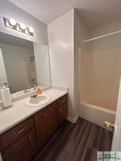 bathroom with vanity, wood-type flooring, a textured ceiling, and walk in shower