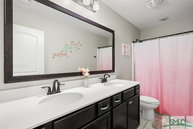 bathroom featuring tile patterned floors, vanity, and toilet