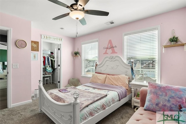 carpeted bedroom with ceiling fan, a closet, and a spacious closet