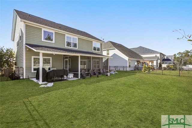 rear view of house with a lawn, outdoor lounge area, and a sunroom