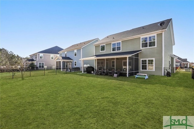 back of house featuring a sunroom and a lawn