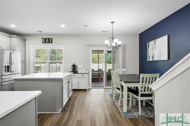 kitchen with a notable chandelier, a center island, stainless steel refrigerator with ice dispenser, and a wealth of natural light