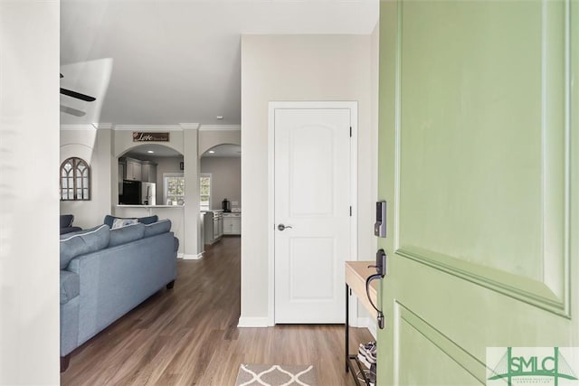 interior space featuring wood-type flooring, ceiling fan, and ornamental molding