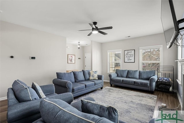 living room with ceiling fan, dark hardwood / wood-style flooring, and a fireplace