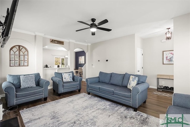 living room featuring ceiling fan with notable chandelier and dark wood-type flooring