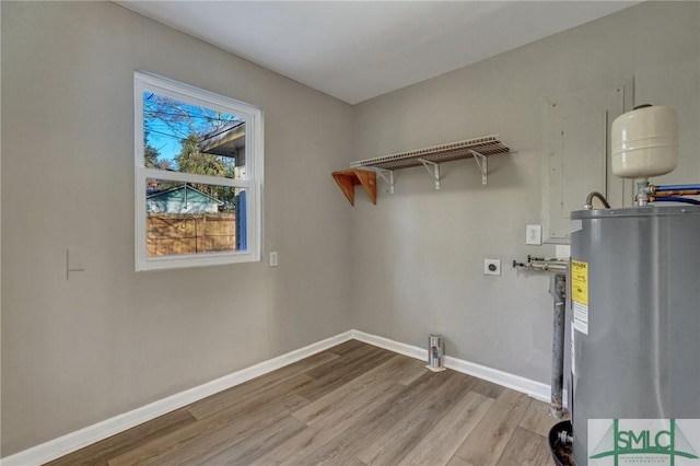 laundry area featuring hookup for an electric dryer, light wood-type flooring, and water heater