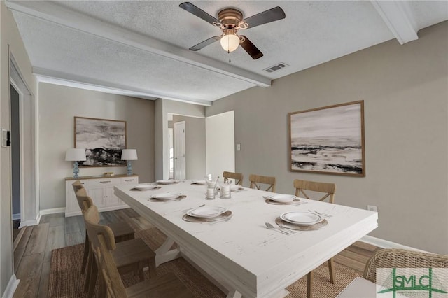 dining area with beam ceiling, a textured ceiling, ceiling fan, and hardwood / wood-style floors