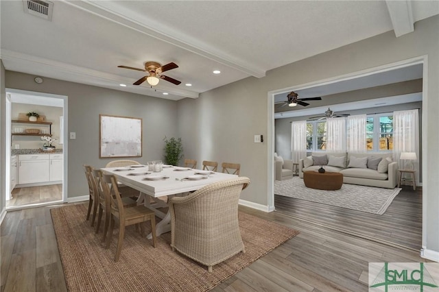 dining space with beamed ceiling, ceiling fan, and hardwood / wood-style flooring