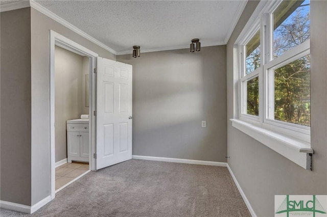 unfurnished room with a textured ceiling, crown molding, and light carpet