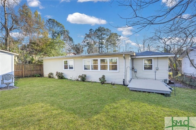 rear view of house with a deck and a lawn