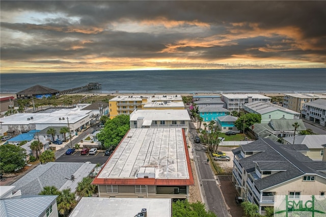 aerial view at dusk featuring a water view