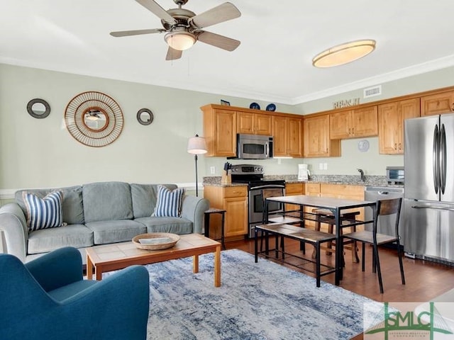 living room featuring dark hardwood / wood-style flooring, ceiling fan, crown molding, and sink