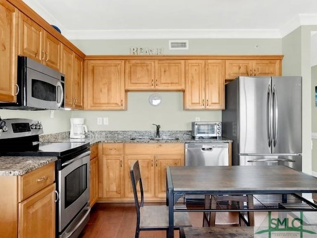 kitchen with light stone countertops, stainless steel appliances, dark wood-type flooring, crown molding, and sink