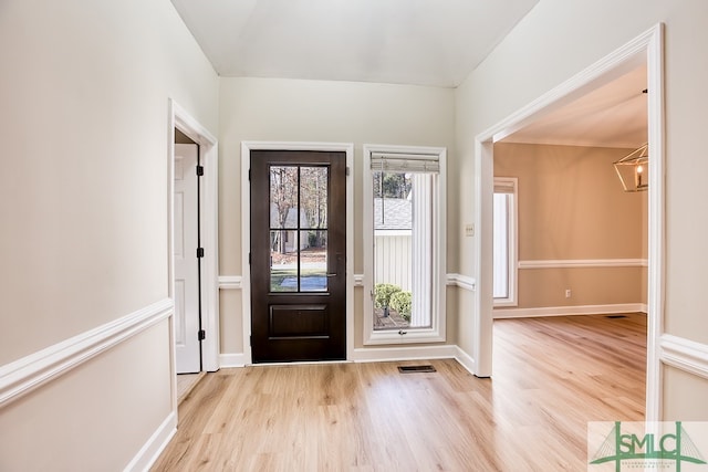 foyer entrance featuring a chandelier and light hardwood / wood-style floors