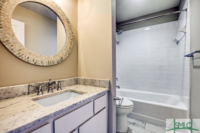 full bathroom featuring vanity, tiled shower / bath combo, and toilet