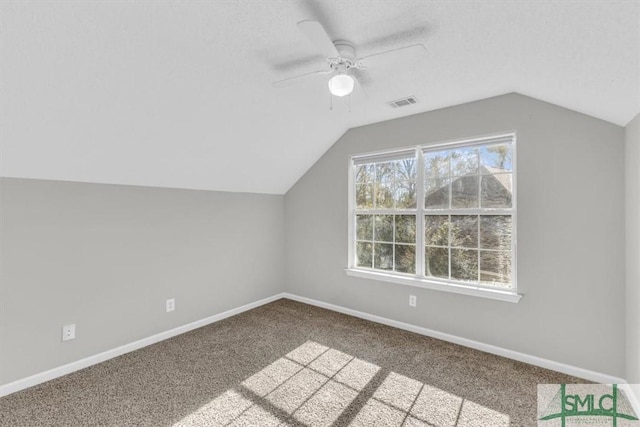 additional living space with ceiling fan, light colored carpet, and vaulted ceiling