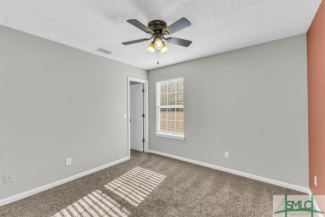 spare room with ceiling fan, carpet floors, and a textured ceiling