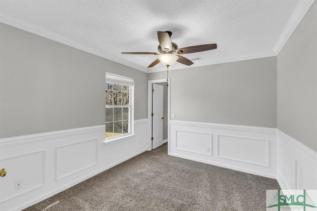 spare room featuring ceiling fan, carpet floors, a textured ceiling, and ornamental molding