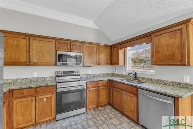 kitchen with light stone countertops, a textured ceiling, stainless steel appliances, sink, and lofted ceiling