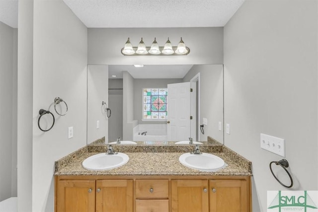 bathroom featuring vanity, a tub to relax in, and a textured ceiling