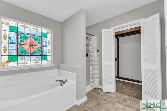 bathroom featuring plus walk in shower and a textured ceiling