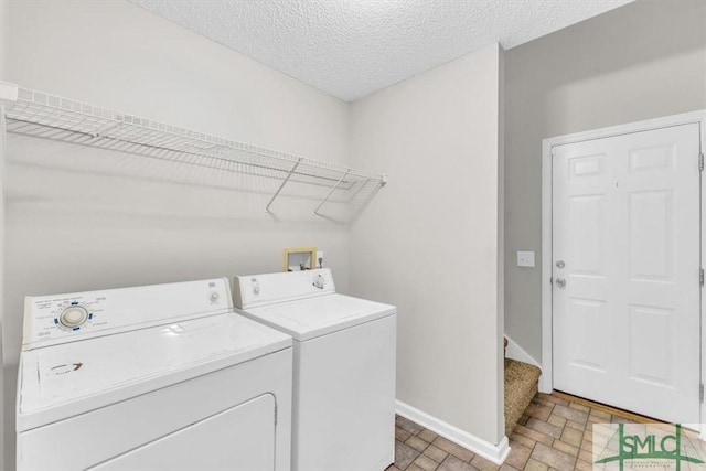 laundry room featuring washing machine and dryer and a textured ceiling