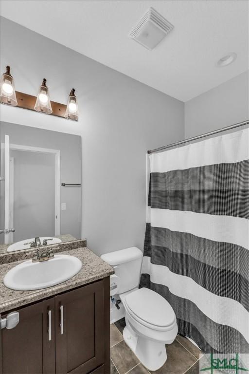 bathroom featuring vanity, tile patterned flooring, toilet, and a shower with shower curtain