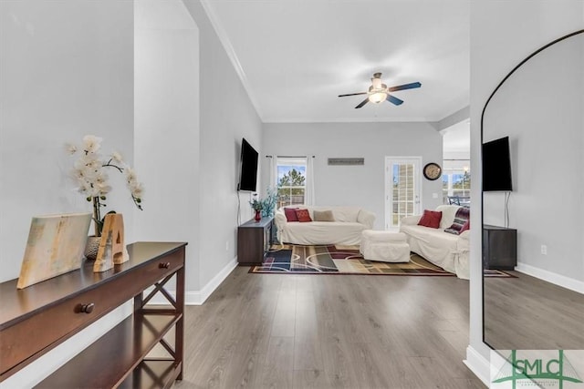 living room featuring crown molding, ceiling fan, and hardwood / wood-style flooring